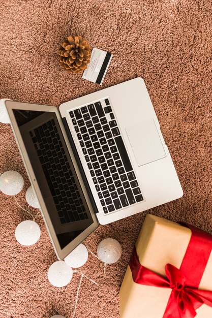 Laptop dichtbij plastic kaart, huidige doos, winkelhaak en feelichten