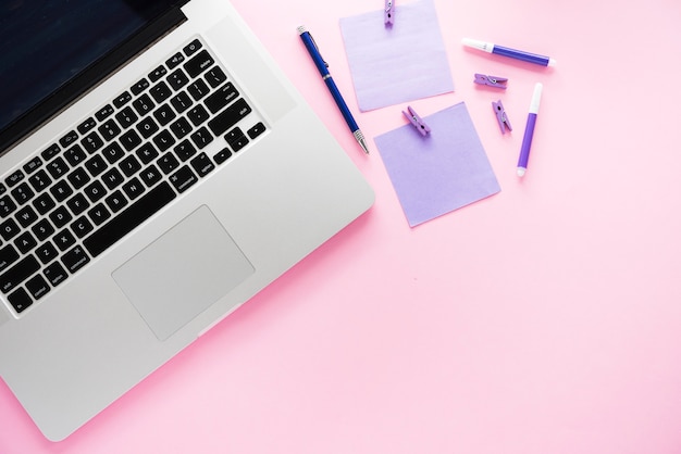 Laptop en benodigdheden met roze achtergrond
