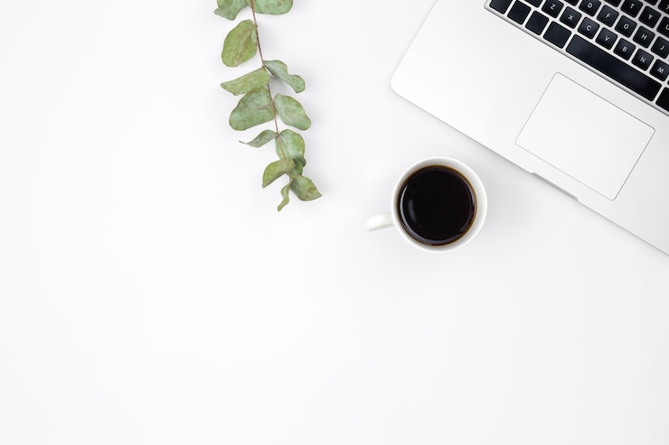 Gratis Foto laptop en een kopje zwarte koffie op een witte achtergrond bovenaanzicht