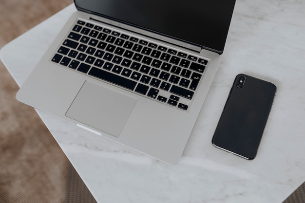 Laptop en een telefoon op een marmeren tafel