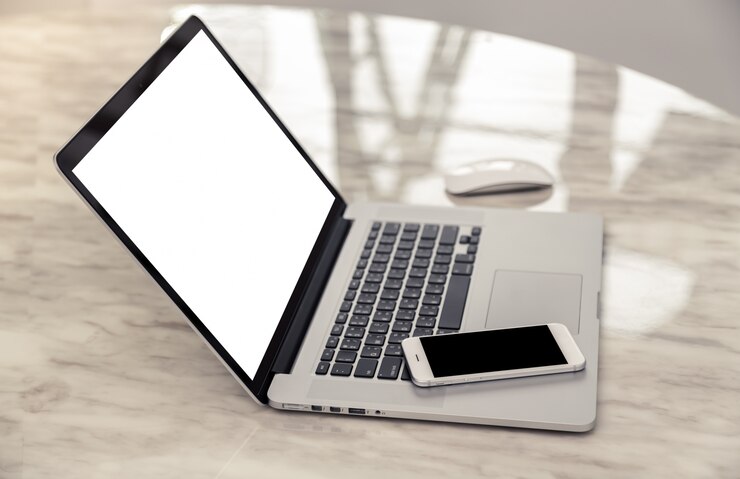 Gratis Foto laptop kant met een smartphone