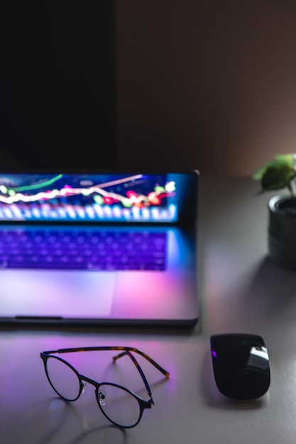 Laptop met grafieken en statistieken en glazen op tafel