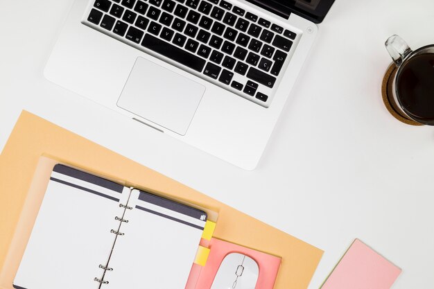 Laptop met notitieboekje en koffiekop