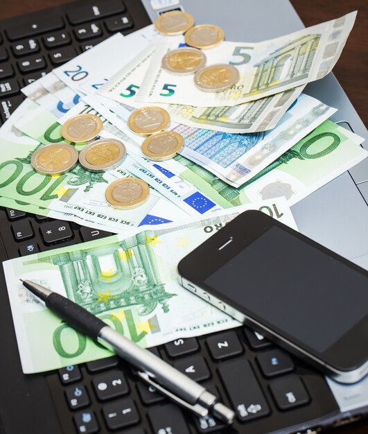 Laptop, mobiel en contant geld op tafel