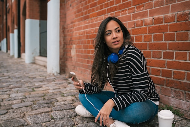 Latijns-vrouw met behulp van mobiele telefoon.