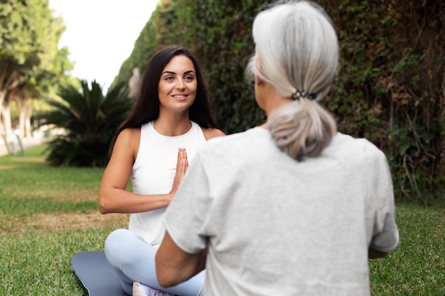 Gratis foto leeftijdsverschil vriendinnen ontmoeten elkaar voor yoga buitenshuis