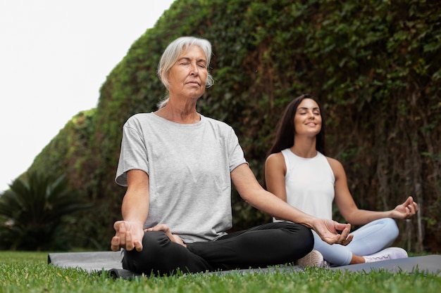 Gratis foto leeftijdsverschil vriendinnen ontmoeten elkaar voor yoga buitenshuis