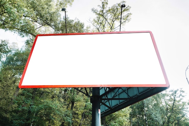 Leeg aanplakbord op achtergrond van bomen