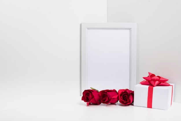 Leeg frame met geschenkdoos en rozen