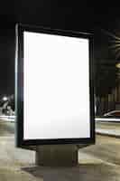 Gratis foto leeg reclamebord met wit scherm op stoep in de nacht