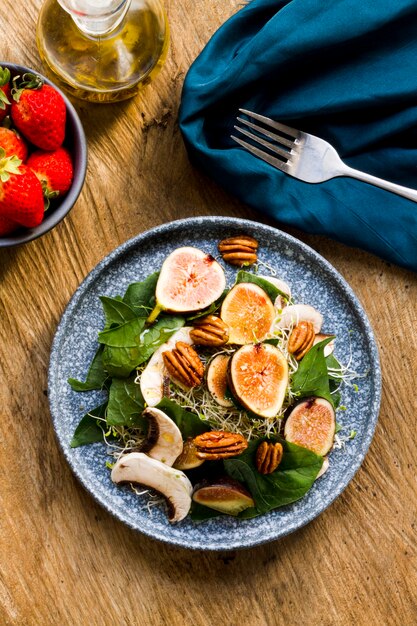 Leg de mix van noten en vijgen plat op een plaat met aardbeien