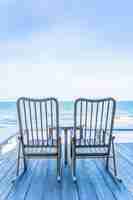 Gratis foto lege houten stoel en tafel op terras met prachtige tropische strand en zee