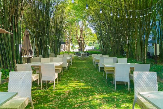 Lege rieten tafel en stoel in openluchtrestaurant met bamboebostuin
