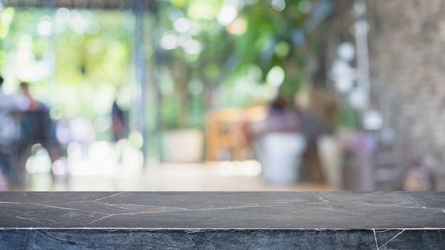 Lege zwarte marmeren stenen tafelblad en wazig coffeeshop, café en restaurant interieur achtergrond - kan worden gebruikt voor het weergeven of monteren van uw producten.