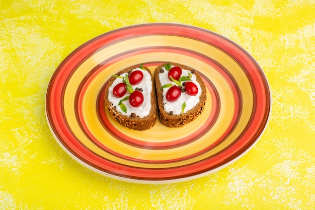 lekker brood toast met zure room en kornoeljes binnen oranje plaat op geel