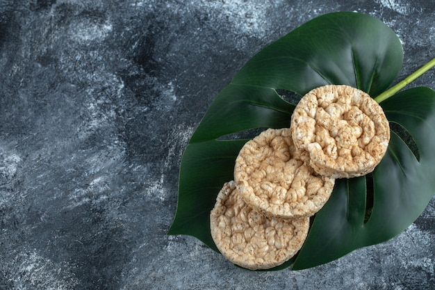 Gratis foto lekker rond knäckebröd op groene bladeren.