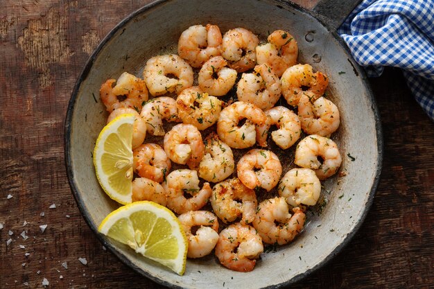 Lekker smakelijk gebakken garnalen op pan op donkere stenen achtergrond. Bovenaanzicht.