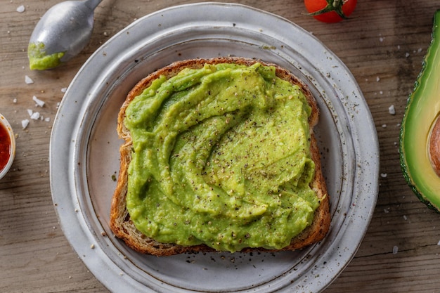 Lekker smakelijk sandwichbrood met gepureerde avocado geserveerd op bord