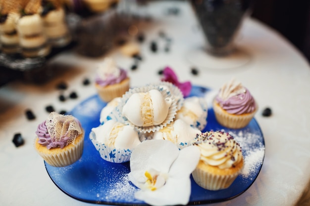 Lekkere cupcakes met room geserveerd op blauwe schotel