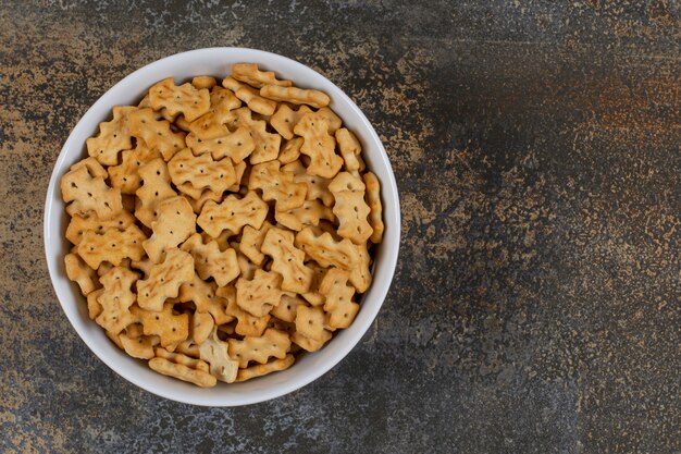 Lekkere gebakken crackers in witte kom.