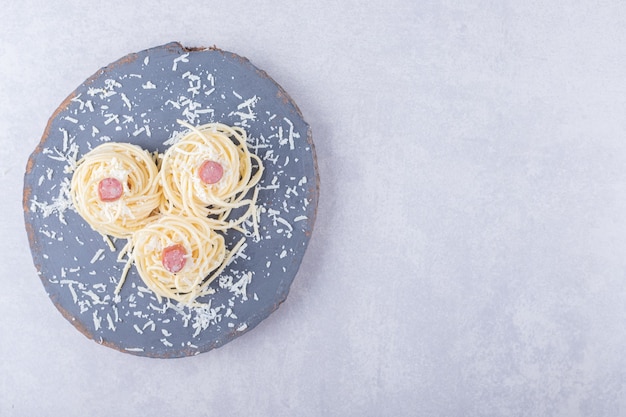 Lekkere gekookte spaghetti met worstjes op stuk hout.