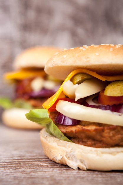 Gratis foto lekkere hamburgers op houten achtergrond. snel en lekker eten