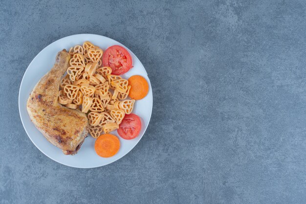 Lekkere pasta met stukjes vlees op witte plaat.