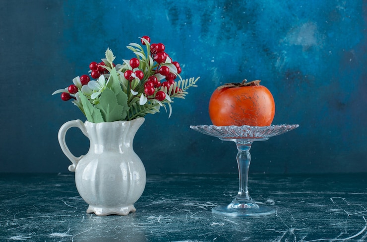 Gratis Foto lekkere rijpe dadelpruim op glasplaat met vaas met bloemen.