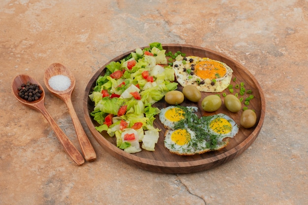 Gratis foto lekkere salade met eieren op een houten bord.