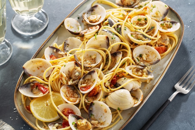 Lekkere smakelijke verse zelfgemaakte mosselen alle vongole zeevruchten pasta met knoflook en witte wijn op plaat. Detailopname.