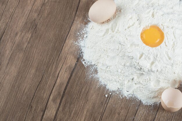 Lekkere taart met ingrediënten op houten tafel.