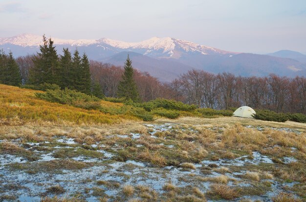 Lente landschap met toeristische tent. kreek van smeltende sneeuw in de bergen. karpaten, oekraïne