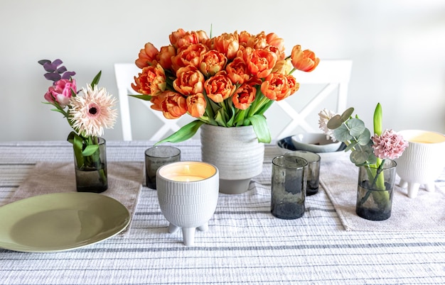 Lentebloemen en kaarsen op tafel in het interieur van de kamer