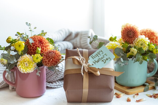 Lentecompositie voor moederdag met een cadeau en chrysantenbloemen