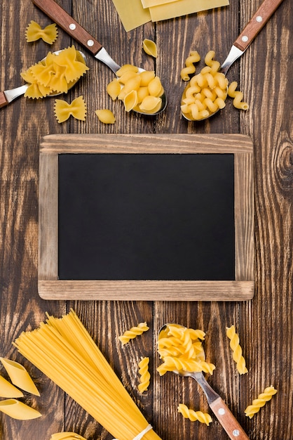 Gratis foto lepels met pasta naast schoolbord