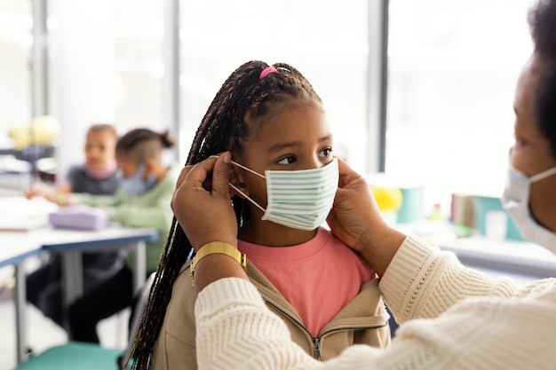 Leraar die een student helpt om een medisch masker op te zetten