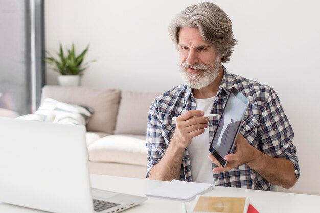 Leraar die tablet toont bij laptop