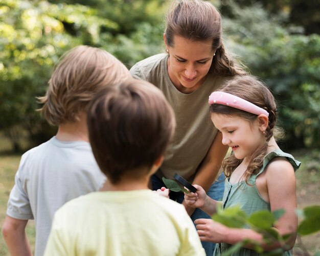 Leraar en kinderen kijken naar bladeren