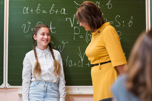 Leraar les uit te leggen aan meisje in de klas