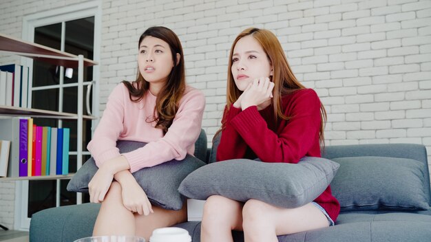 Lesbisch Aziatisch paar dat terwijl thuis het letten van op drama in TV in woonkamer schreeuwt