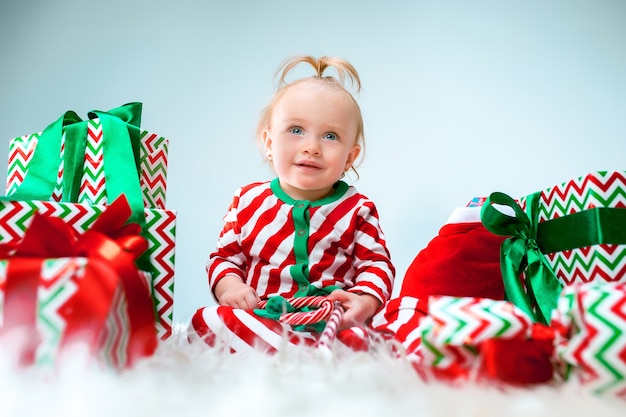 Leuk babymeisje 1 éénjarigen dichtbij santahoed die tijdens kerstmis stellen