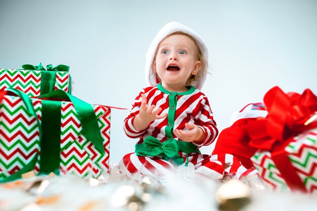 Leuk babymeisje 1 éénjarigen die santahoed dragen die tijdens Kerstmis stellen