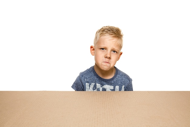 Gratis foto leuk en boos jongetje dat het grootste postpakket opent.