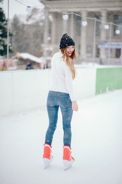 Leuk en mooi meisje in een witte trui in een winterstad