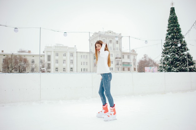 Leuk en mooi meisje in een witte trui in een winterstad
