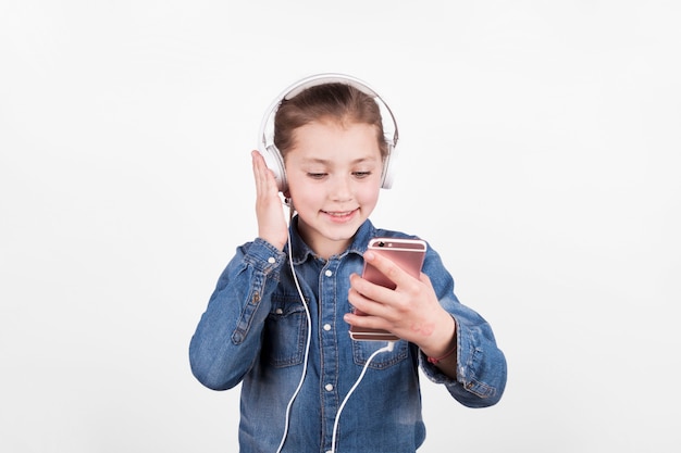 Leuk meisje dat aan muziek luistert en smartphone gebruikt