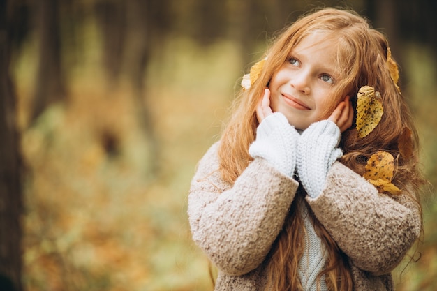 Leuk meisje met lang rood haar in herfstbos