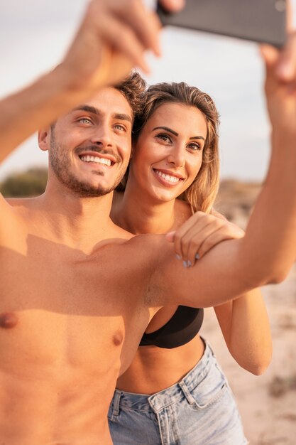 Leuk paar bij strand dat selfie neemt