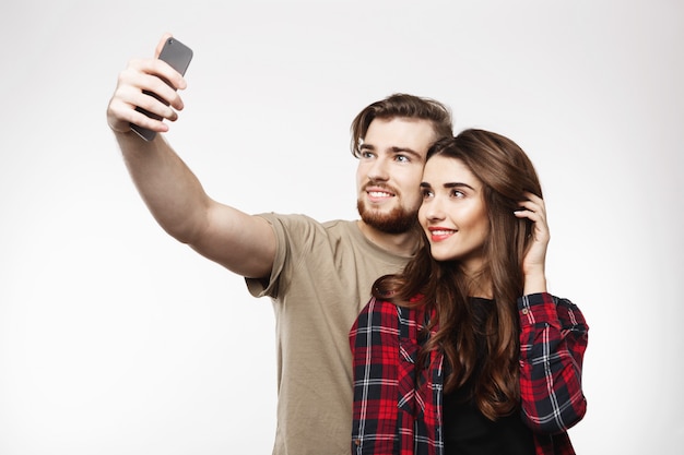 Leuk vrolijk paar nemen selfie op telefoon, op zoek gelukkig.