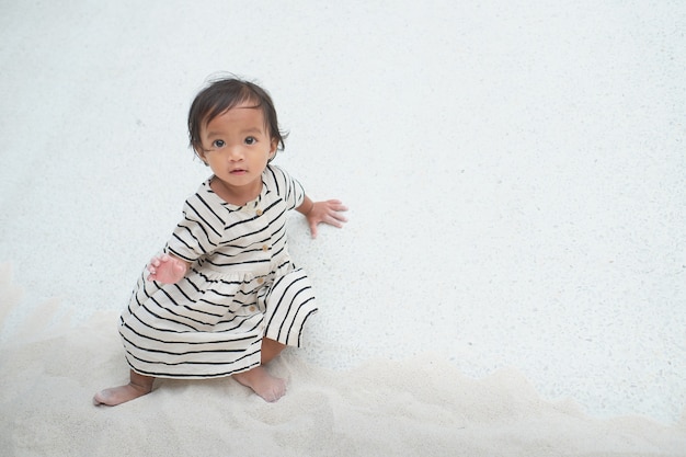 Leuke aziatische 1-2 jaar oude peuter baby meisje kind spelen met zand in zandbak op openbare speelplaats, ontwikkeling van fijne motoriek voor klein kind met kopieerruimte